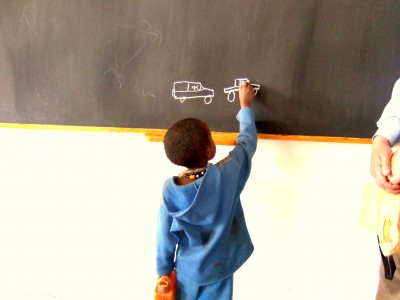 A young student showing off his artistic side with the rest of his class at one of imagine1day's schools